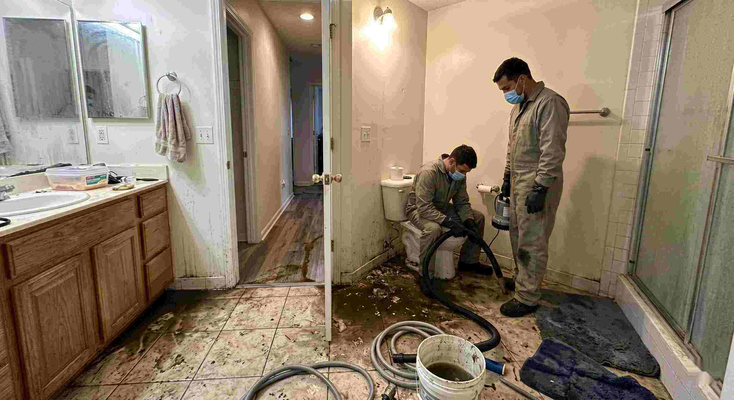 Septic tank backup cleanup in Chesapeake bathroom with technicians removing contaminated water and sanitizing affected areas